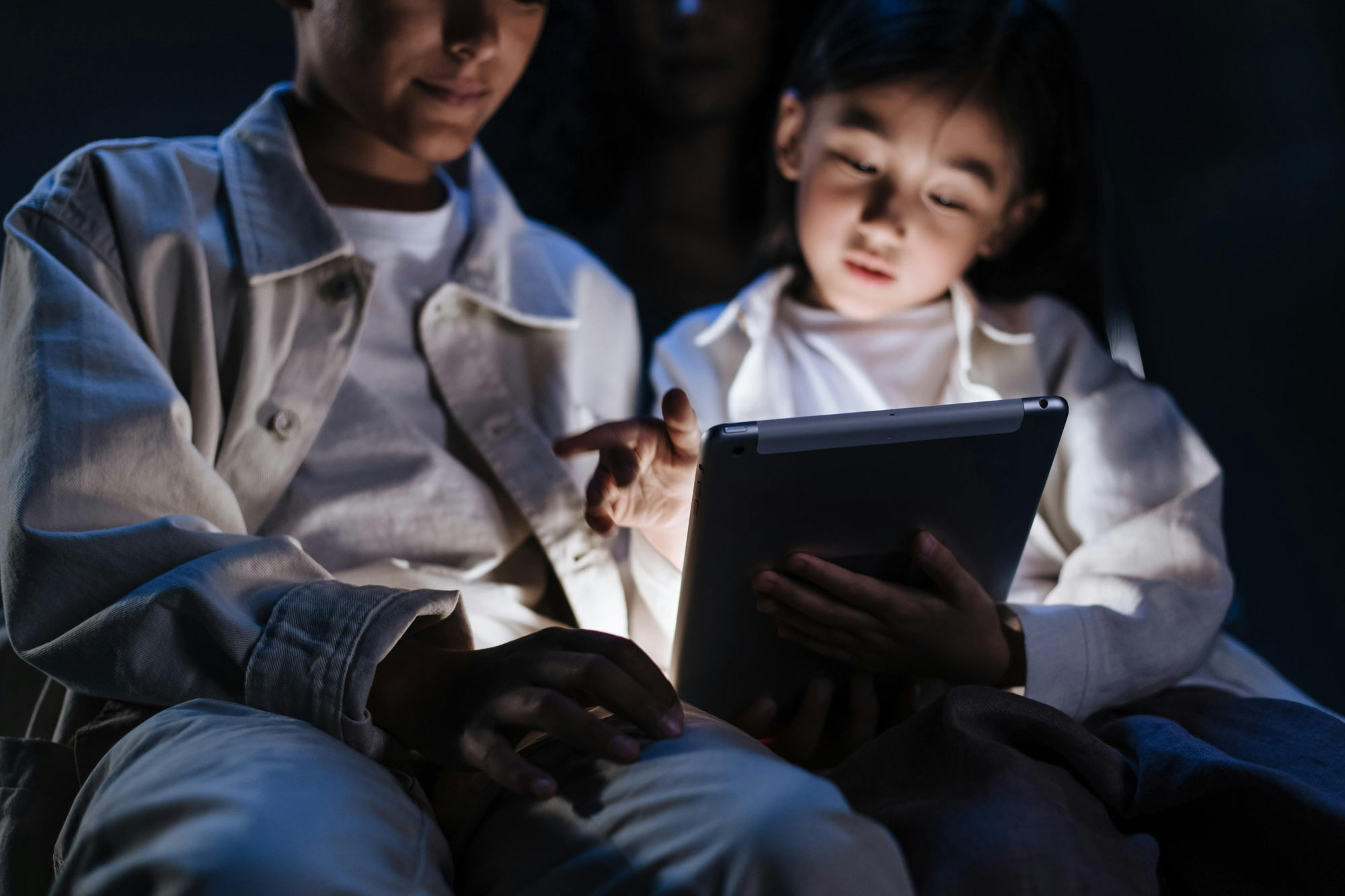 Image of a father and son reading on a tablet together